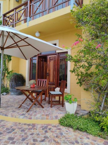 a patio with a table and chairs and an umbrella at Villa Tartaruga in Sedgefield
