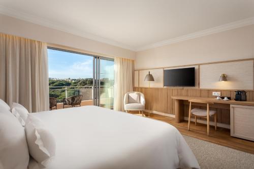 a hotel room with a bed and a large window at Grande Real Santa Eulalia Resort & Hotel Spa in Albufeira
