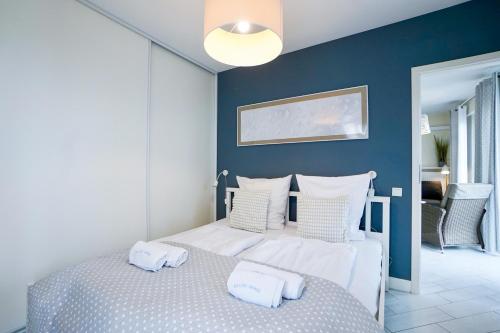 ein Schlafzimmer mit einem Bett mit zwei Handtüchern darauf in der Unterkunft Horyzont by Baltic Home in Misdroy