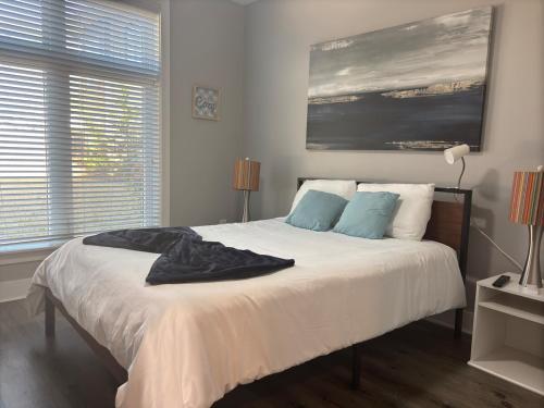 ein Schlafzimmer mit einem Bett mit weißen Laken und blauen Kissen in der Unterkunft Luxury 2BR Gated Community Pets Parking in Greenville