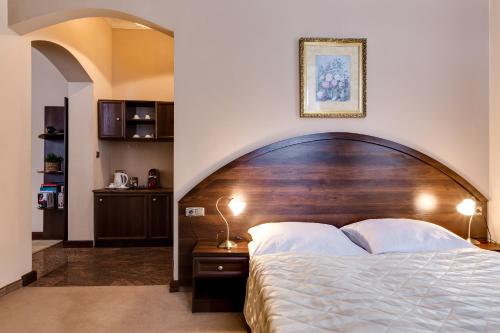 Schlafzimmer mit einem großen Bett mit einem Kopfteil aus Holz in der Unterkunft Pałac Spiż koło Karpacza in Karpacz