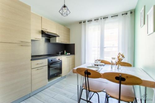 une cuisine avec une table et des chaises dans une pièce dans l'établissement Le Borelys Parking Gratuit, à Saleilles