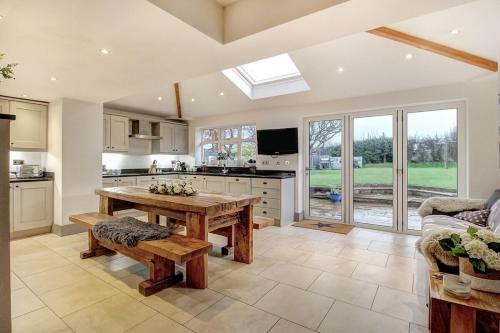 a kitchen with a wooden table and a couch at The Family Holiday In West Kirby By Cheshire Escapes in Wirral