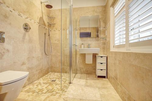 a bathroom with a shower and a toilet and a sink at The Family Holiday In West Kirby By Cheshire Escapes in Wirral