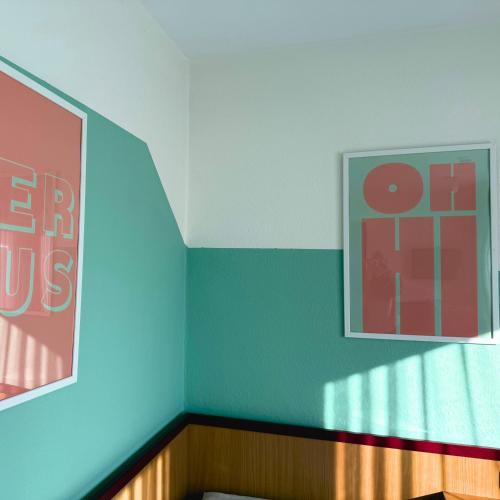 a corner of a room with two pictures on the wall at Colourful Hotel in Bielefeld