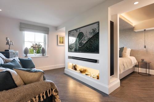 a living room with a tv and a bed at The Retreat in Penruddock