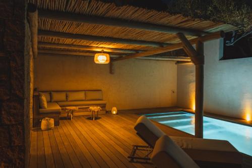 Cette chambre dispose d'une piscine, d'un canapé et d'une table. dans l'établissement Casi di Mare, à Cargèse