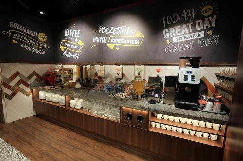 un restaurant avec un comptoir et un café dans l'établissement Hampton By Hilton Gdansk Old Town, à Gdańsk