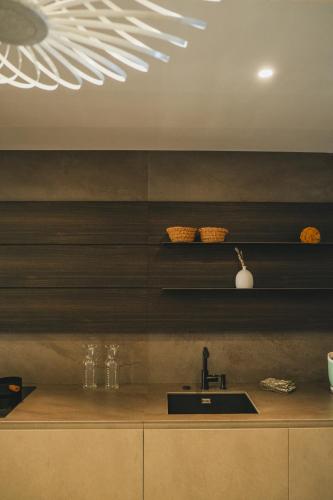 Il comprend une cuisine avec un évier et un plafond blanc. dans l'établissement Casi di Mare, à Cargèse