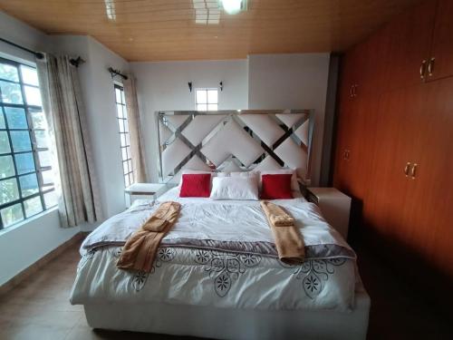 a bedroom with a large bed with red pillows at 4Br Beautiful Mansion Mombasa rd in Nairobi