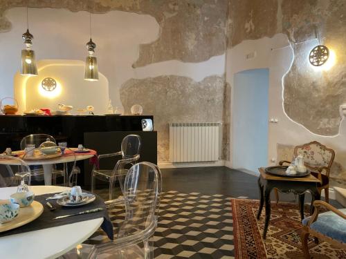 a dining room with tables and chairs in a room at Palazzo Siena De Facendis in Bitonto