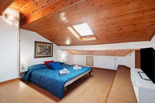 a bedroom with a blue bed and a wooden ceiling at Affittacamere Monica in Levanto