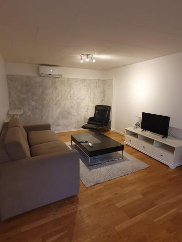 a living room with a couch and a tv at 3 rum och kök 4 bäddar in Oskarshamn