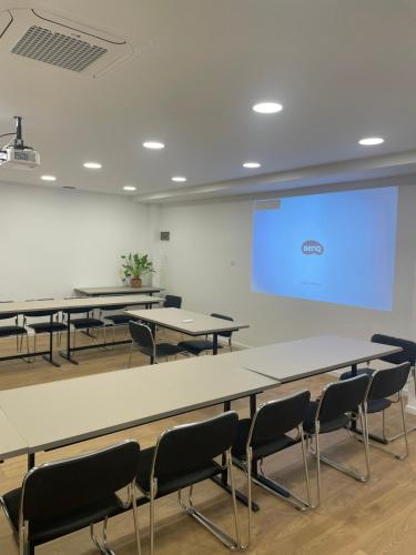 a classroom with tables and chairs and a projection screen at Electra Hotel in Stavros