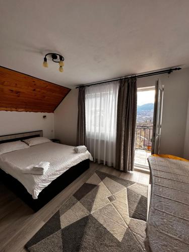 una camera da letto con un letto e una grande finestra di Dor de munte a Măgura