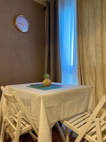 une table avec une citrouille assise et deux chaises dans l'établissement Cozy studio, à Brétigny-sur-Orge
