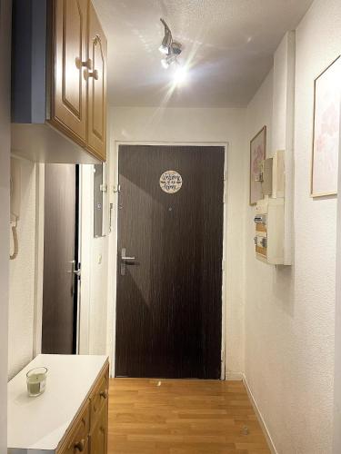 Il comprend une cuisine avec une porte noire et du parquet. dans l'établissement Cozy studio, à Brétigny-sur-Orge