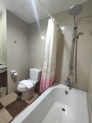 a bathroom with a toilet and a bath tub at Baan Manthana Hotel, Hua Hin in Hua Hin