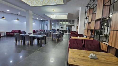 ein Speisesaal mit Tischen und Stühlen in einem Restaurant in der Unterkunft Albatros Premium Hôtel in Jaunde