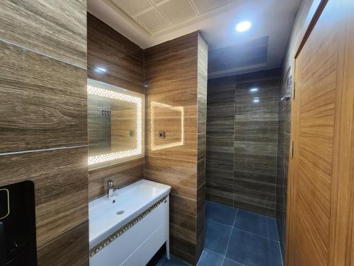 ein Badezimmer mit Waschbecken und Spiegel in der Unterkunft Albatros Premium Hôtel in Jaunde