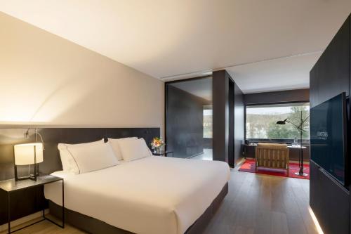 Un dormitorio con una cama grande y una ventana grande. en Eurostars Pamplona, en Pamplona