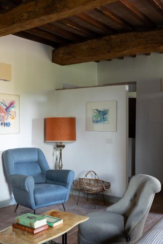a living room with two chairs and a table at La Fattoria del Rio di Sopra - Agriturismo Baldeschi in Tuoro sul Trasimeno