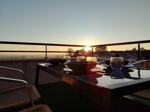 une table avec des bols et des verres sur un balcon dans l'établissement Panorama, à Dammartin-en-Goële