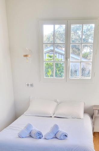 une chambre blanche avec un lit avec deux serviettes dessus dans l'établissement Villa - Libellules - Emplacement Prenium, à Hossegor