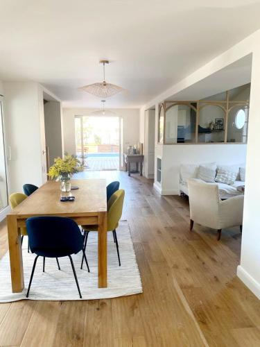 une salle à manger et un salon avec une table et des chaises dans l'établissement Villa - Libellules - Emplacement Prenium, à Hossegor