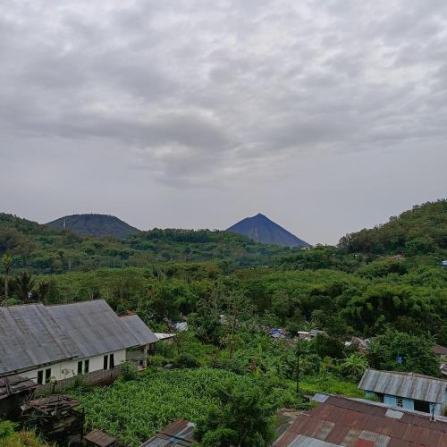 a view of a village with mountains in the background at Kristian Homestay in Bajawa