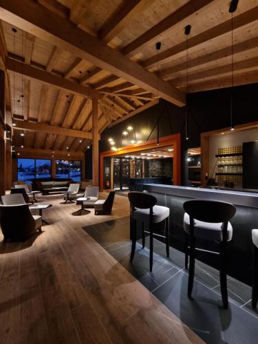 a bar in a restaurant with tables and chairs at MGM Hôtels & Résidences - Résidence Le Hameau de l'Ours in Manigod