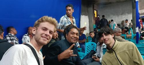 a group of men sitting in a crowd at Kristian Homestay in Bajawa