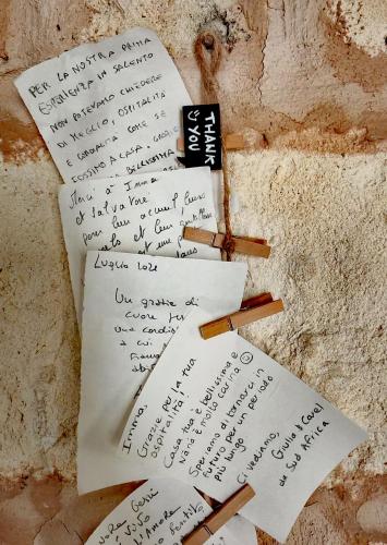 two pieces of paper with writing on a wall at Nanà Maison in Nardò