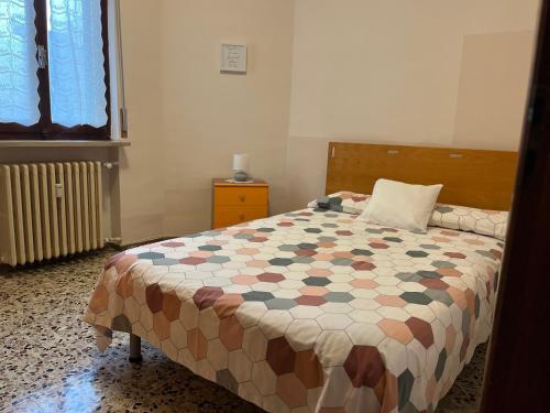 a bedroom with a bed with a quilt on it at Casa Piemont in Casale Monferrato