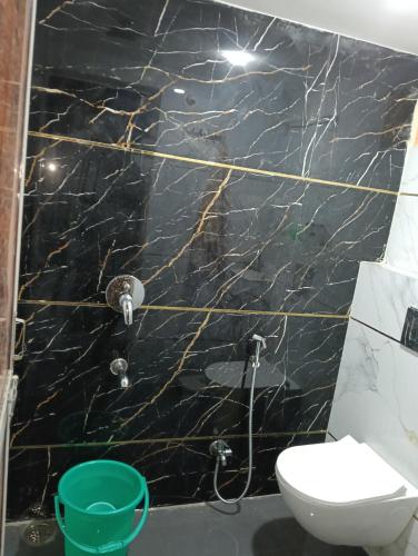 a bathroom with a black marble wall at Luxe Shree Krishna Kunj Villa in Ujjain