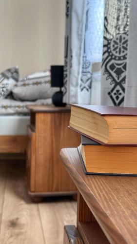 a stack of books sitting on a table in a bedroom at Apartament u Bartosów in Czarny Dunajec
