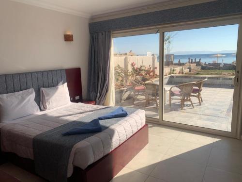 a bedroom with a bed and a view of a patio at Nubia Island View Dahab in Dahab