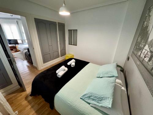 a bedroom with a bed with two towels on it at Apartamento Jardín de San Feliz / Fontán in Oviedo