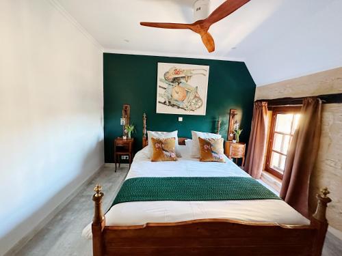 een slaapkamer met een bed met een groene muur bij Le Chevrefeuille chambres d'hotes et gîtes de charme in Meyrals
