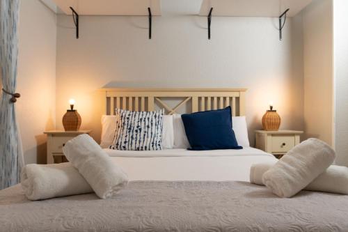 a bedroom with a large white bed with two pillows at Alma de Zahara in Zahara de los Atunes