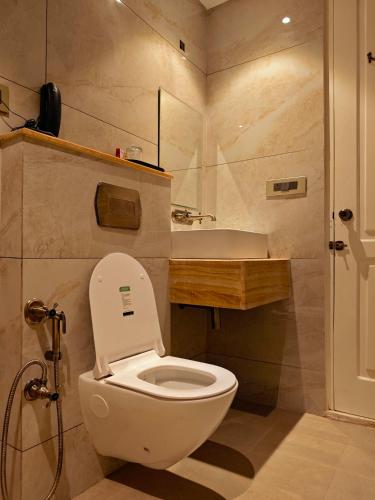 a bathroom with a white toilet and a sink at Gauri Gangaa in Haridwār