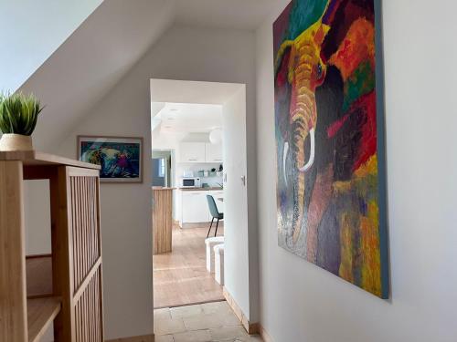 un couloir orné d'une peinture colorée sur le mur. dans l'établissement Logis du Prieuré by Melrose, à Saint-Vigor-le-Grand