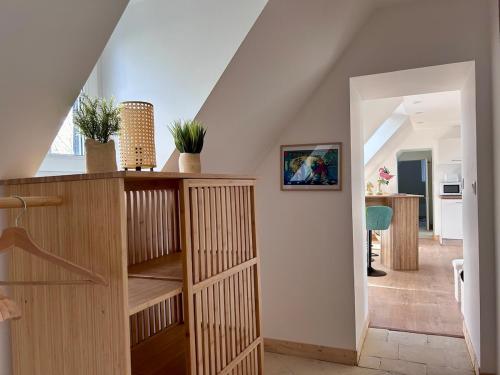 une pièce avec un escalier avec une étagère en bois dans l'établissement Logis du Prieuré by Melrose, à Saint-Vigor-le-Grand