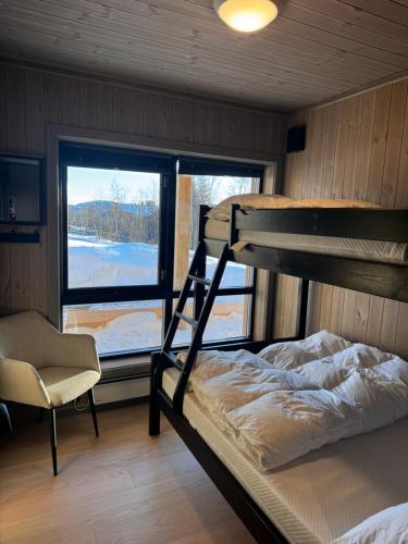 a bunk bed in a room with a window at New modern cabin in Beitostølen in Beitostøl