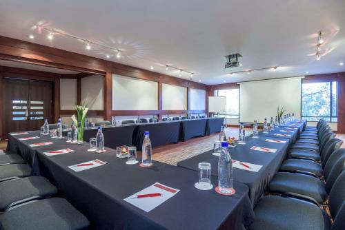 a conference room with long tables and chairs at NH Collection Bogota Hacienda Royal in Bogotá