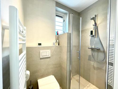 a bathroom with a shower with a glass door at Holiday home Zeeroos in Koudekerke