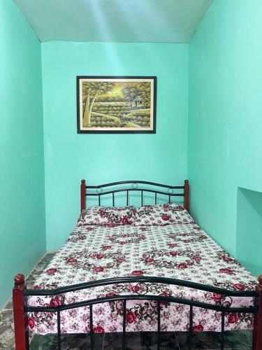 a bed in a bedroom with a blue wall at Zia's homestay-2 in Siquijor