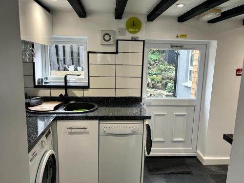 a kitchen with a sink and a washing machine at Penchwintan in Bangor