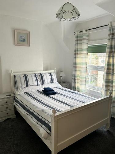 a bedroom with a white bed with a window at Penchwintan in Bangor