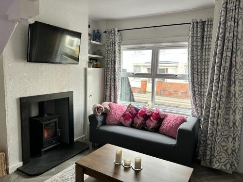 a living room with a couch and a fireplace at Penchwintan in Bangor